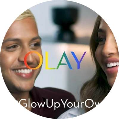 Two people smiling with text overlayed that reads 'Olay Let's #GlowUpYourOwnWay'