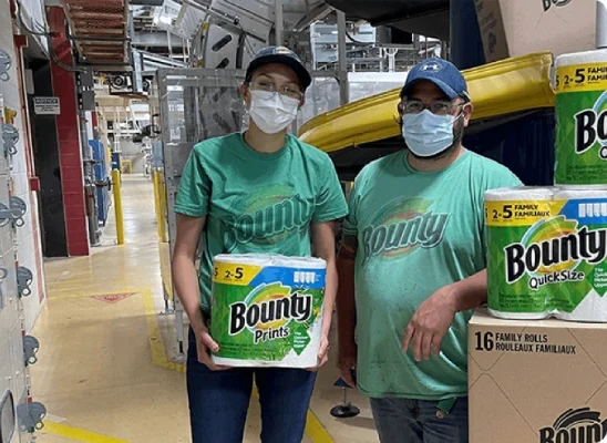 Two person standing holding Bounty product and looking towards the camera. They are wearing a green T-shirt with Bounty logo.