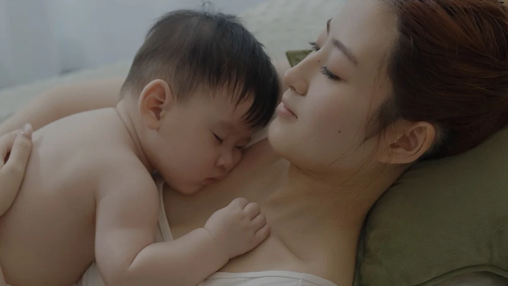 Mother holding her sleeping baby against her chest