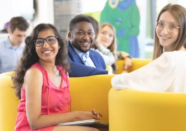 Two women and a man sitting and smiling