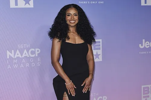 Aylani Ottley posing on the red carpet at the 56th NAACP Image Awards with event branding in the background.