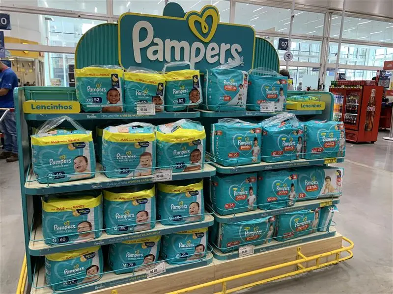 A shelf display of Pampers-branded diapers in different sizes are located center-aisle in a grocery store in Brazil.