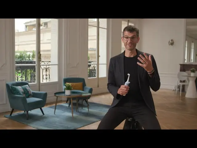 A man holding a toothbrush while talking