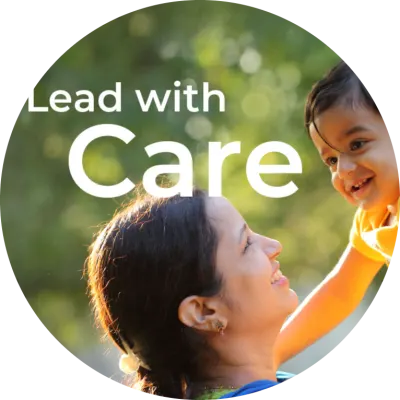 A woman with dark hair holds up her young son with short, curly dark hair. They're both smiling, indicating an expression of joy. The tagline "Lead With Care" is written in white text in the upper left corner. 
