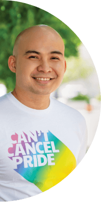 A man smiles while wearing a "Can't Cancel Pride" t-shirt.