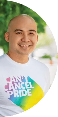 A man smiles while wearing a "Can't Cancel Pride" t-shirt.