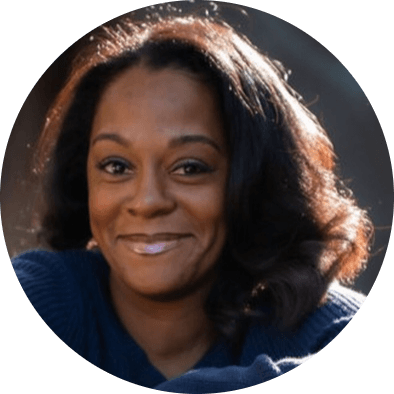 A woman with long black hair is smiling directly towards the camera.  