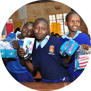 Girls holding Always products in classroom