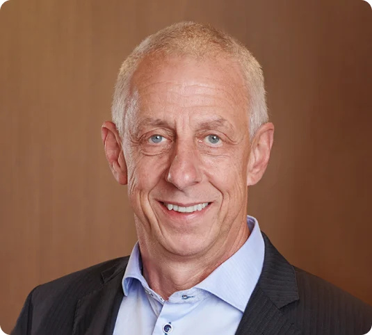 Luc Reynaert, Chief Product Supply Officer, Executive Sponsor for People with Disabilities Network looking towards the camera and smiling. He is wearing a light blue shirt and dark striped suit blazer.