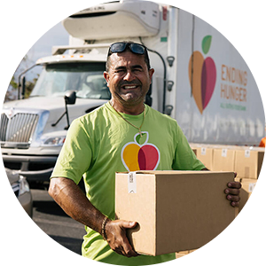 A Feeding America volunteer distributes food donations to alleviate food insecurity.