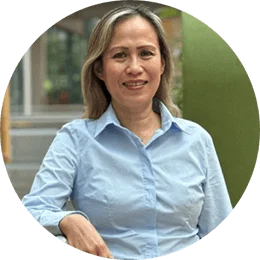 An Asian woman with shoulder length blonde hair in a light blue collared shirt. 