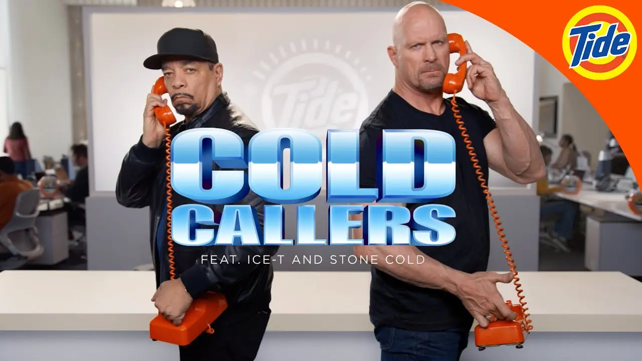 Ice-T and Stone Cole standing with phones in their hands