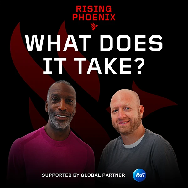 A black man in a red shirt and a white man in a grey shirt stand together and smile. A black background features red and white text at the top that says “Rising phoenix. What does it take?”