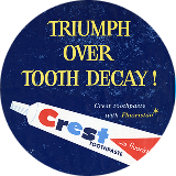 Crest toothpaste tube with blue, red, and white branding and promotional text