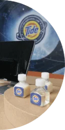 Several bottles of Tide Infinity with a computer in the background