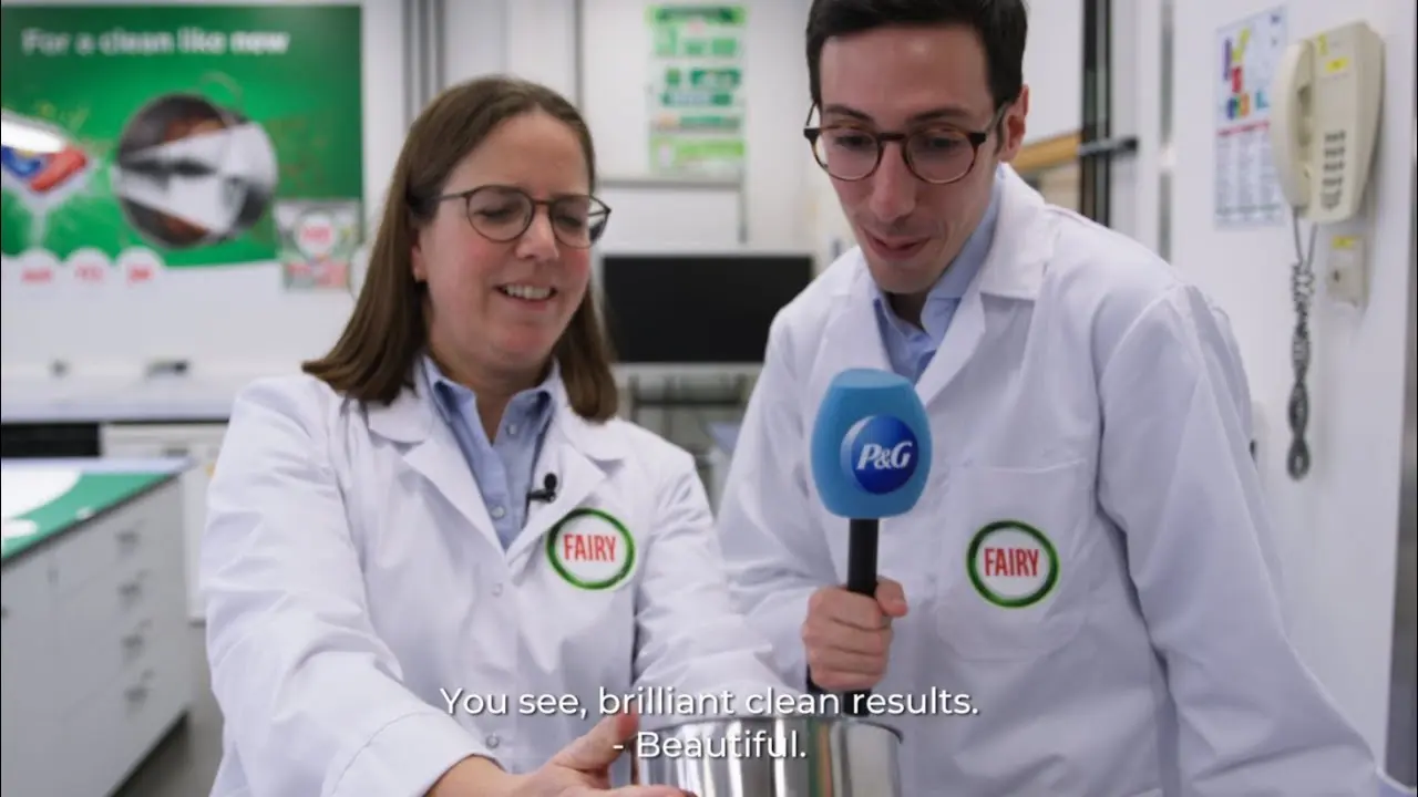 Two people talking wearing white coats with Fairy logo