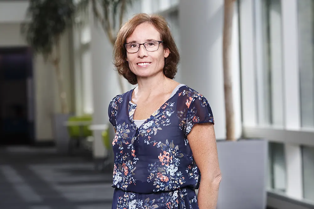 Jennifer standing and smiling for a photo.