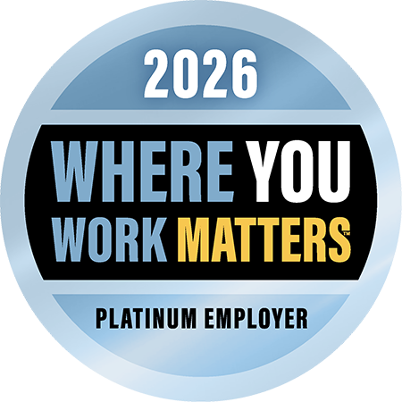 A blue circular badge with a black band and bold text in blue, yellow, white and black reads, “2026. Where you Work Matters, Platinum Employer”
