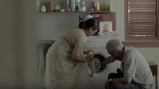 Erkek ve kadın çamaşır makinesini yüklüyor