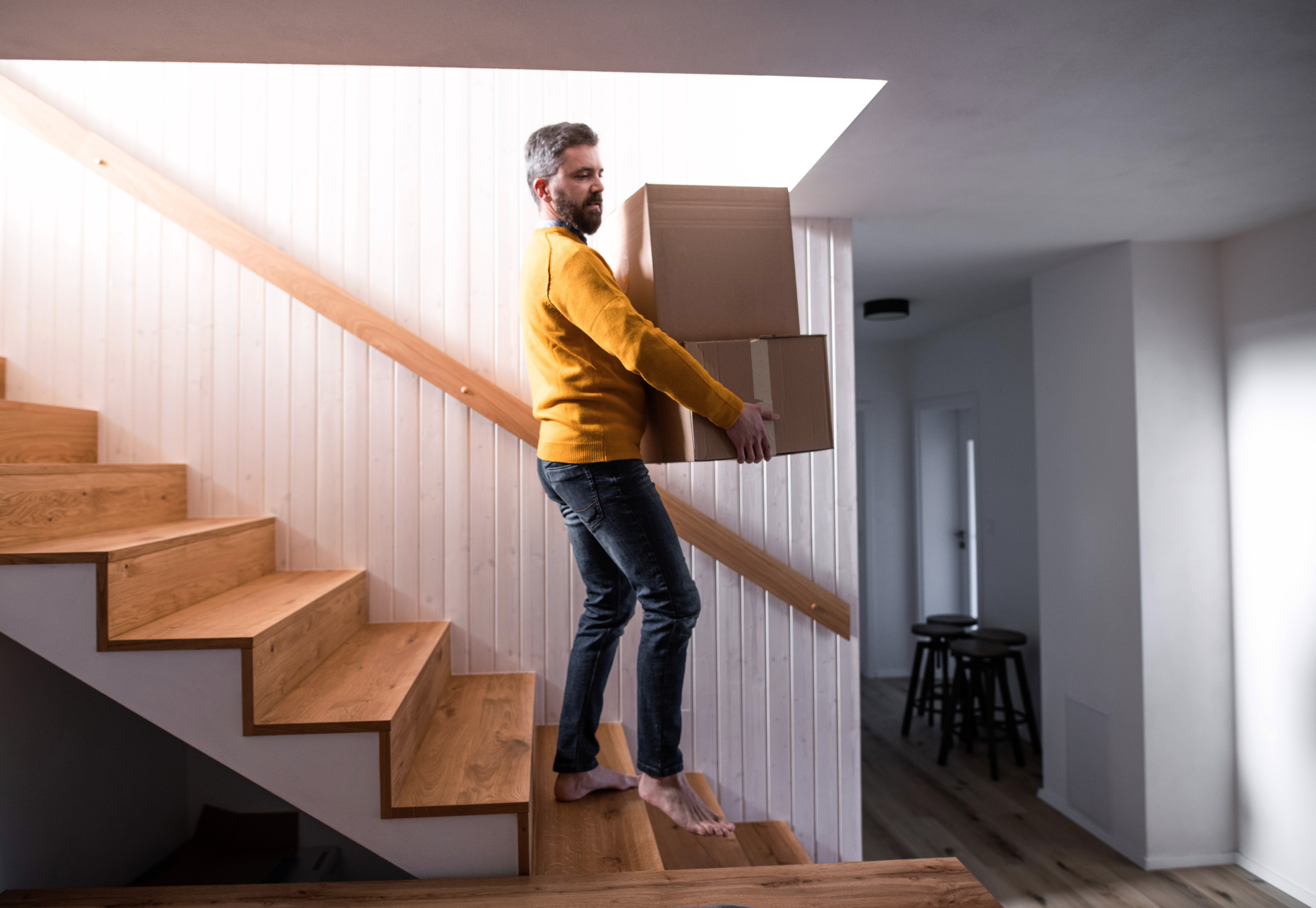 Cover Image for mature-man-walking-down-stairs-in-house-holding-m-2022-02-02-04-51-11-utc