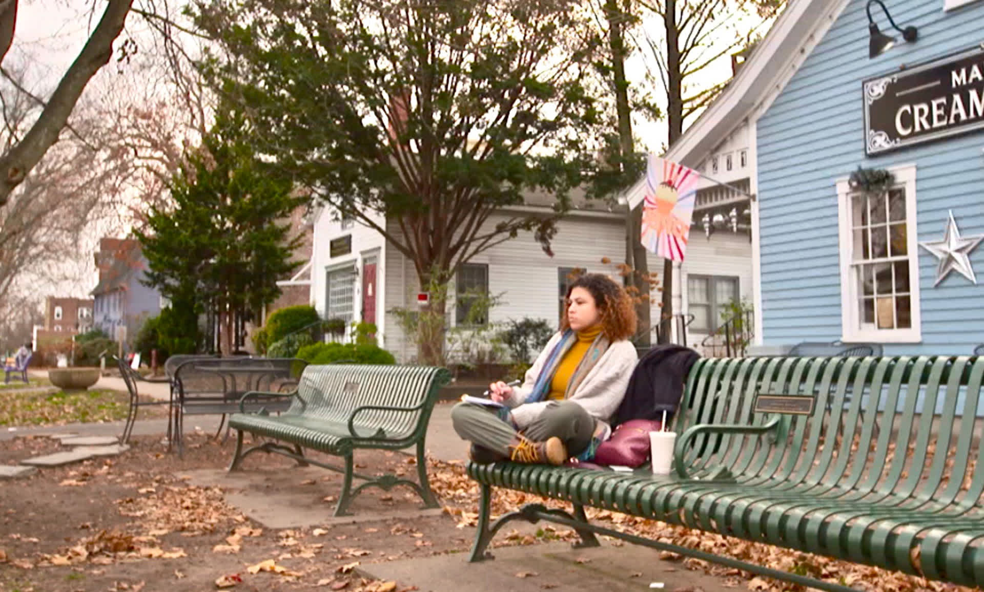 Samantha sits on a bench with her journal