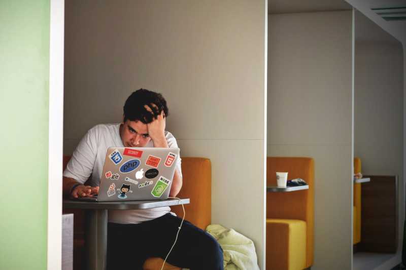 a frustrated man sitting at his laptop