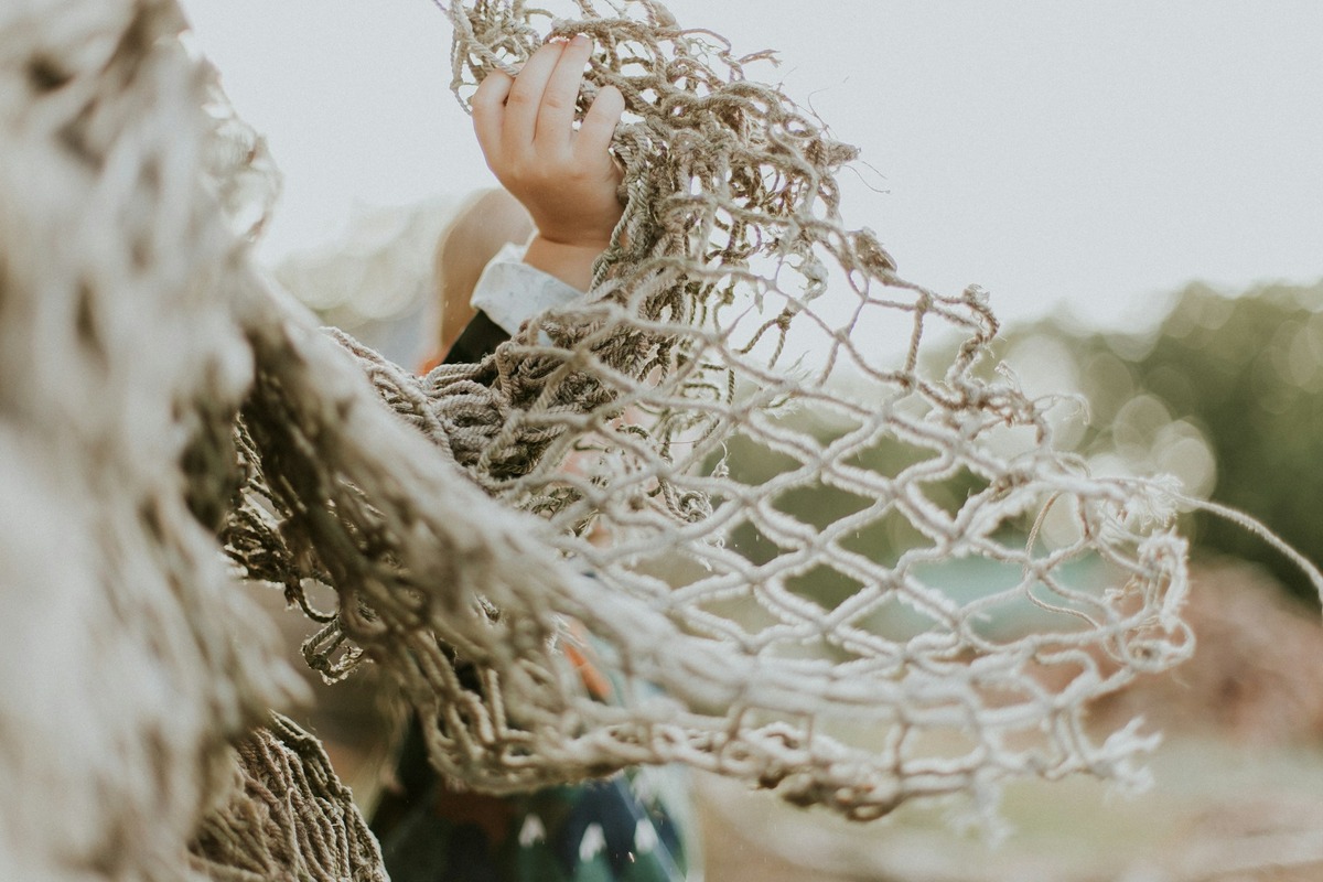 Man in suit holding a net that is coming apart