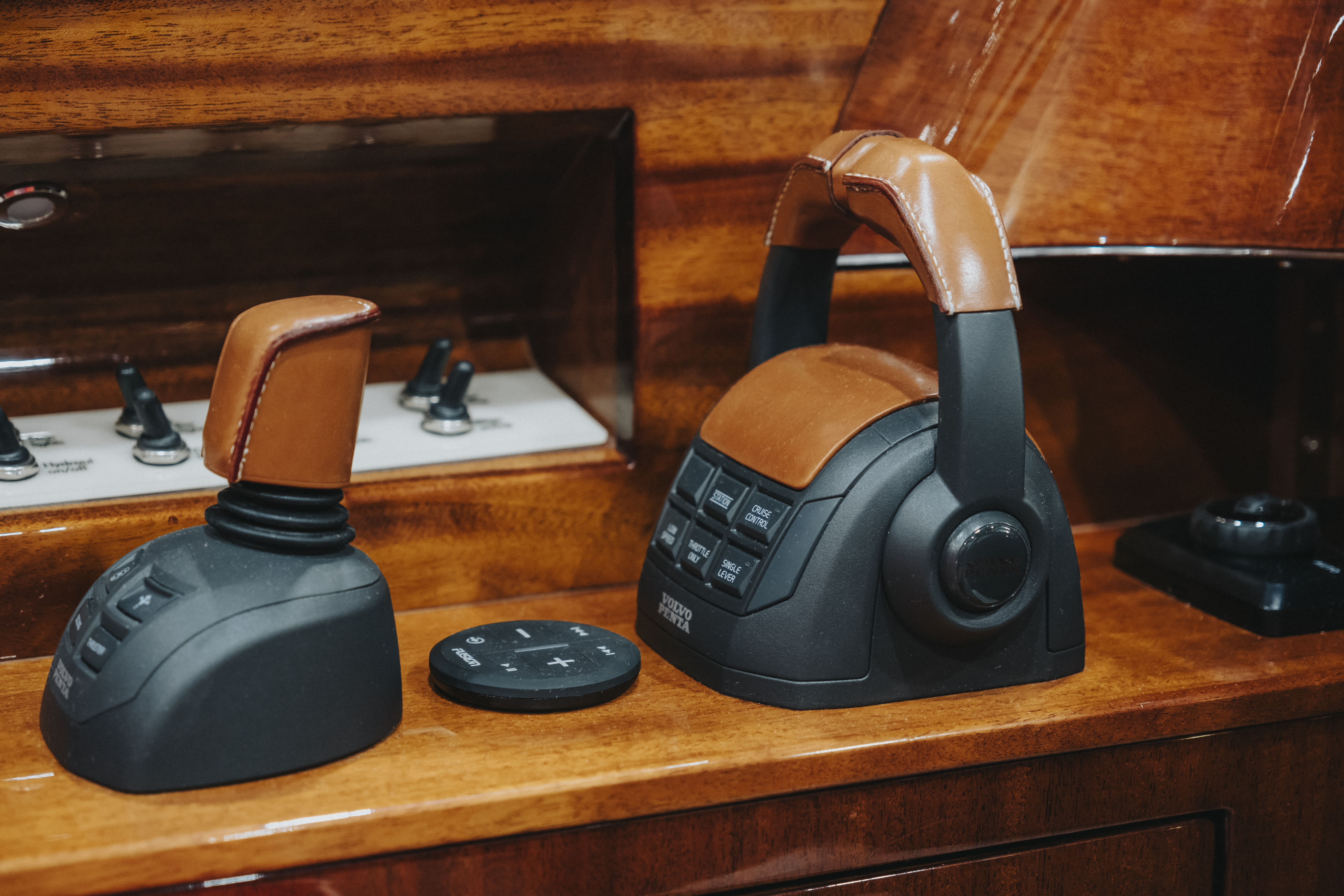 Leather-wrapped Volvo Penta throttle and joystick controls set into lacquered mahogany console