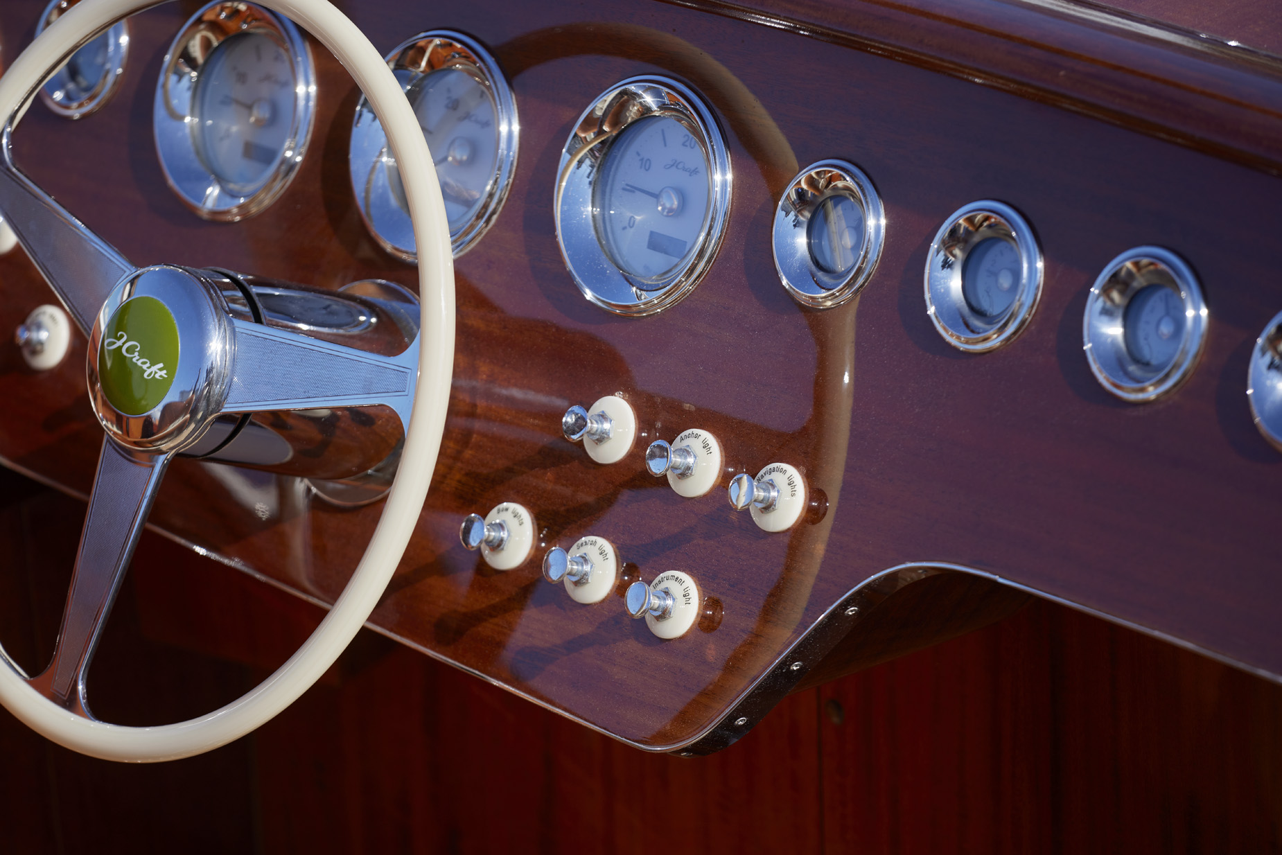 J Craft dashboard detail showing ivory steering wheel, chrome-ringed gauges, and porcelain toggle switches