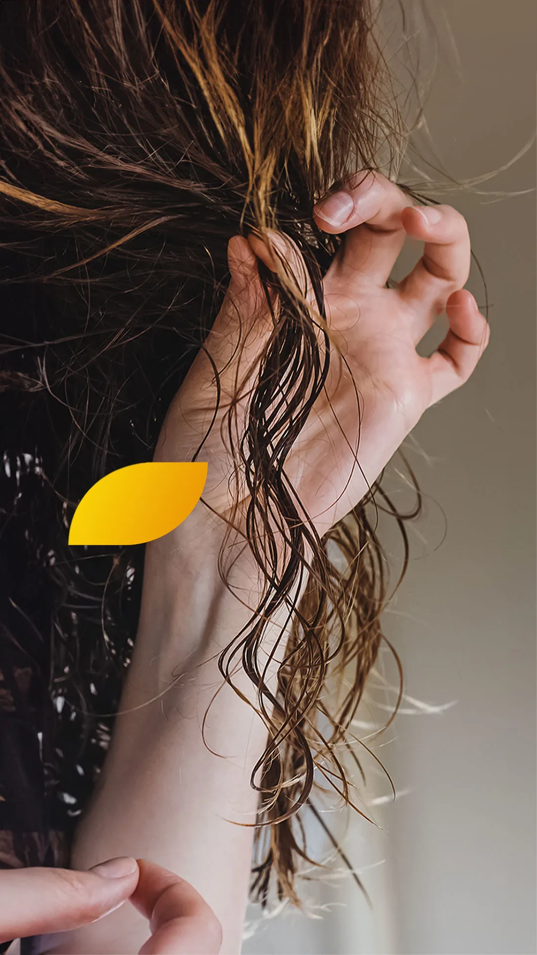 A photo of a woman in towel checking her hair disappointed standing on a pink background