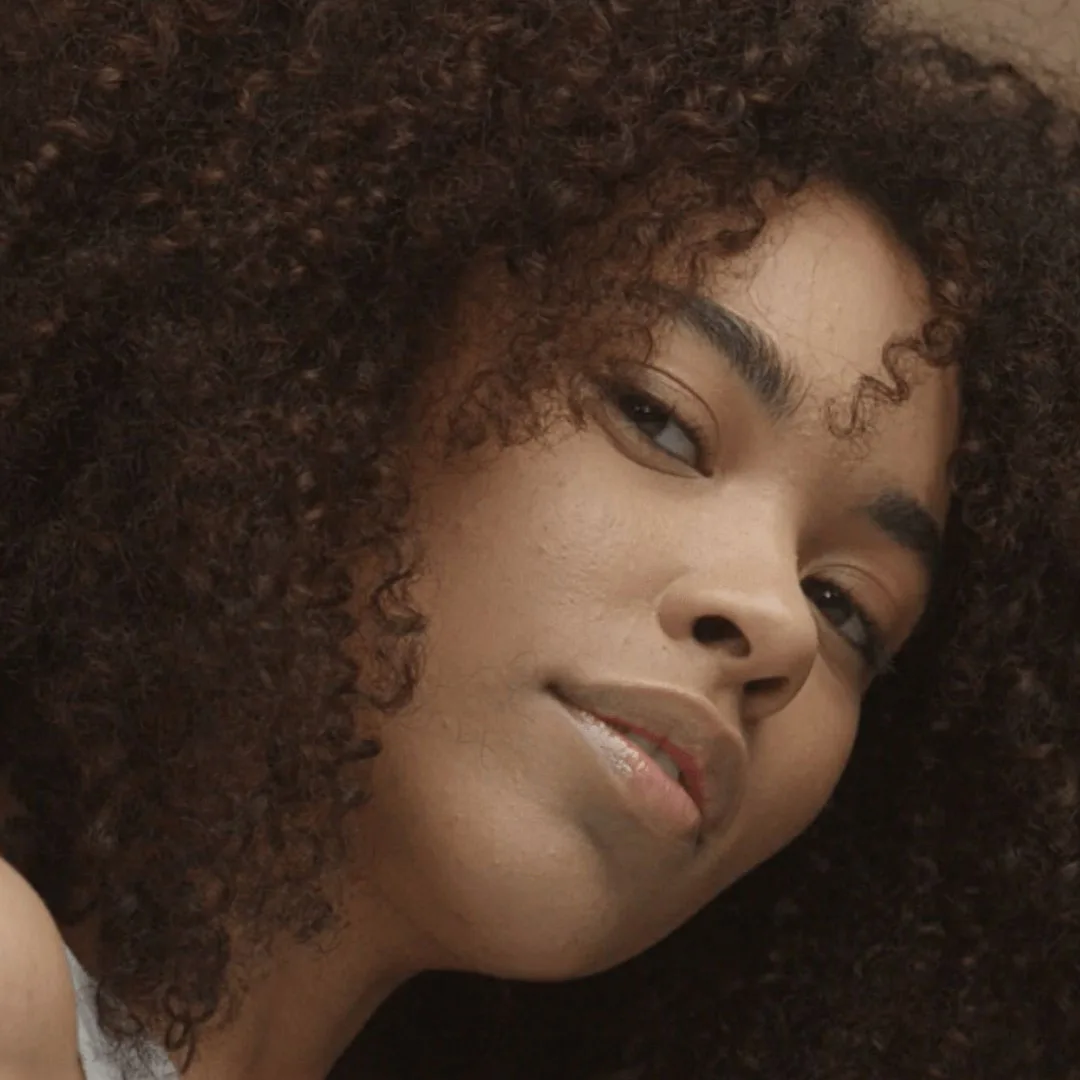 Portrait photograph of a woman with very curly brown hair