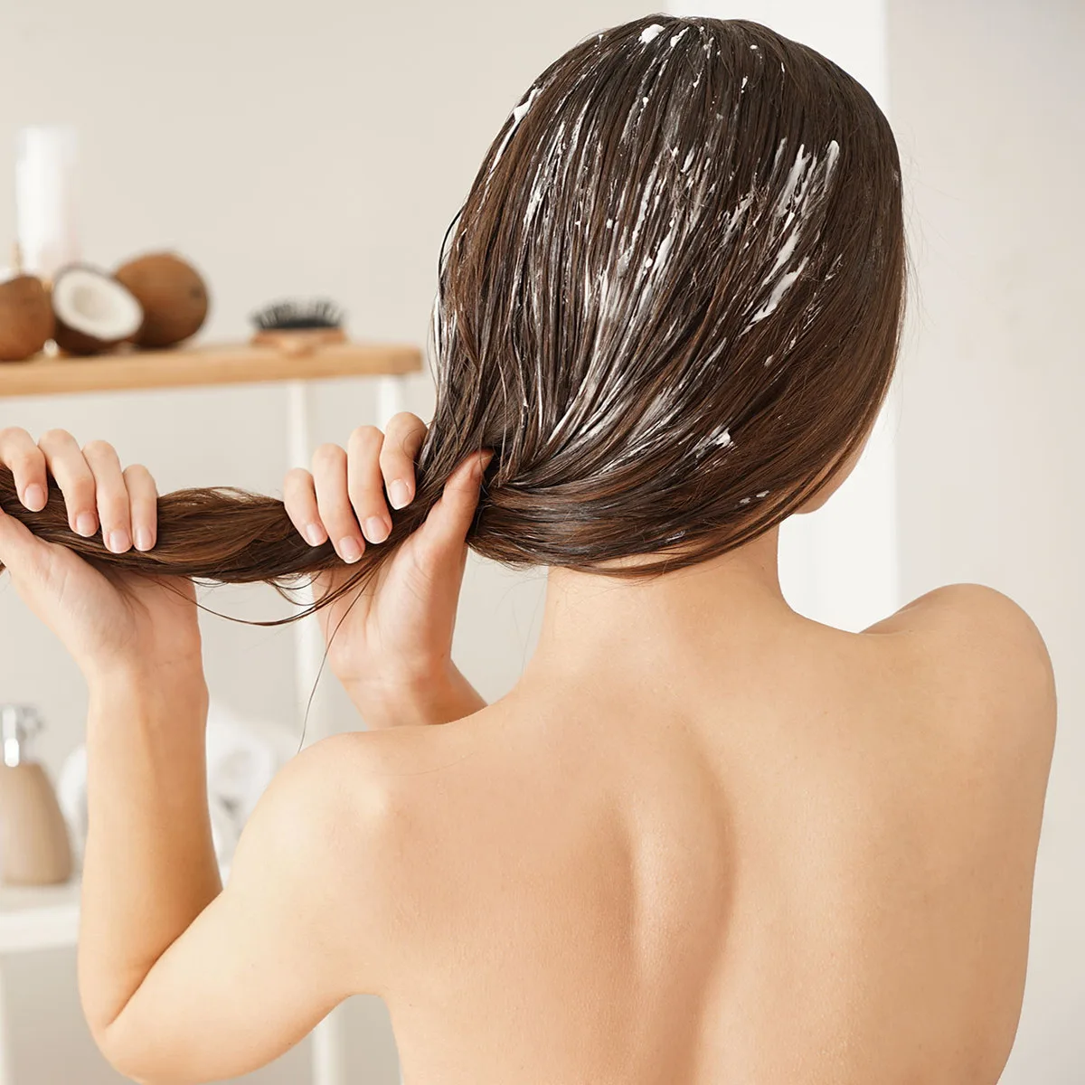 A close up photo of a hand during hair washing, the foam between the dark hair