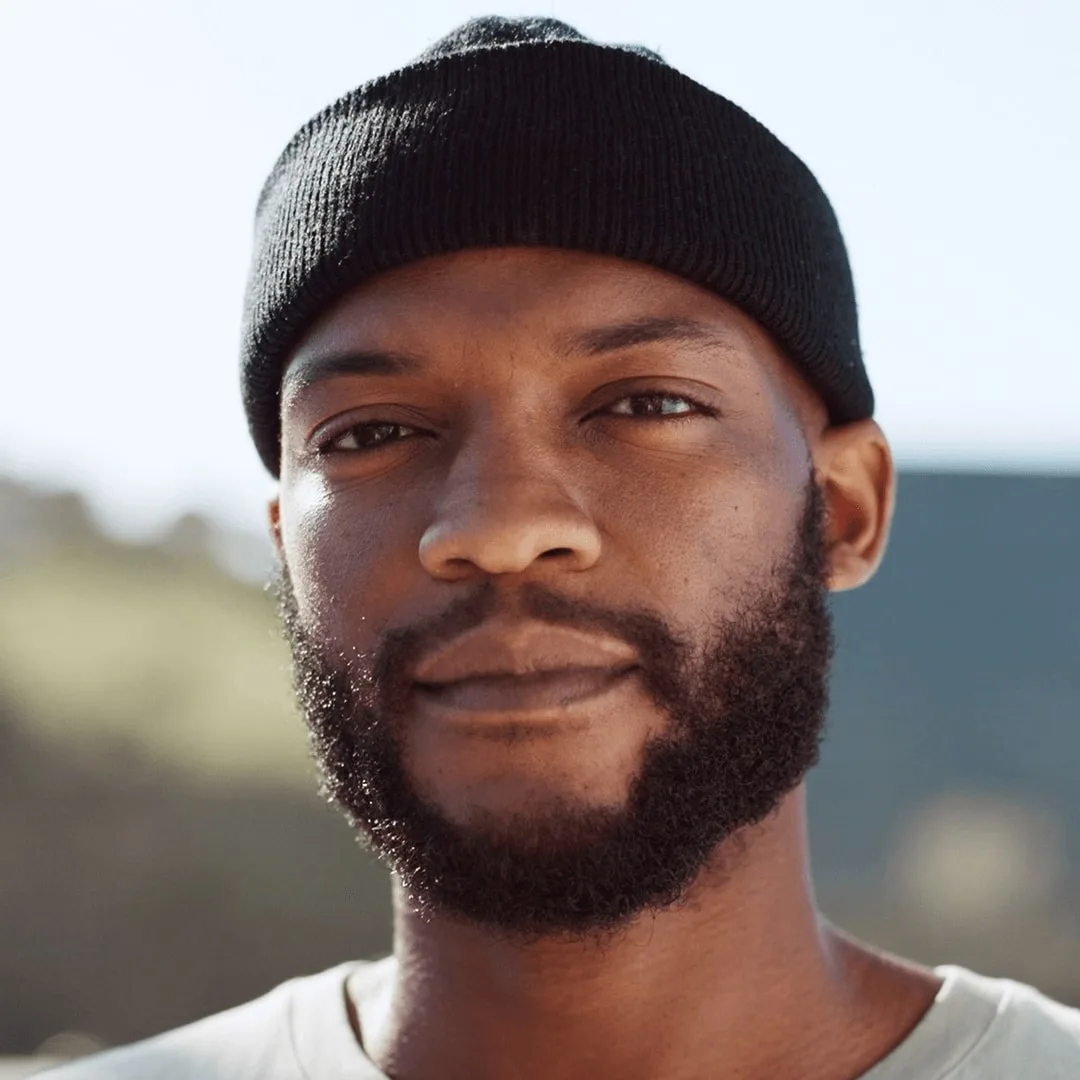 Portrait of a bearded man wearing a black hat.