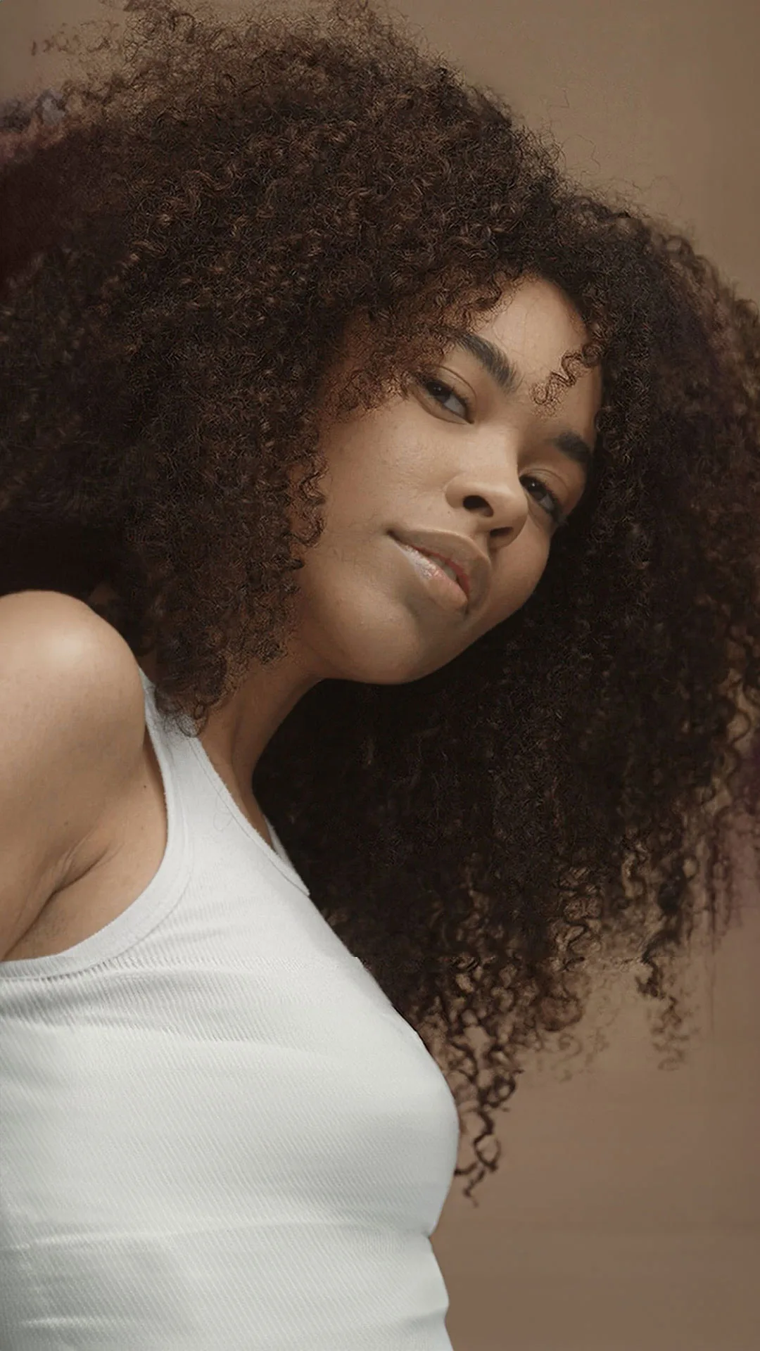 Portrait photograph of a woman with very curly brown hair