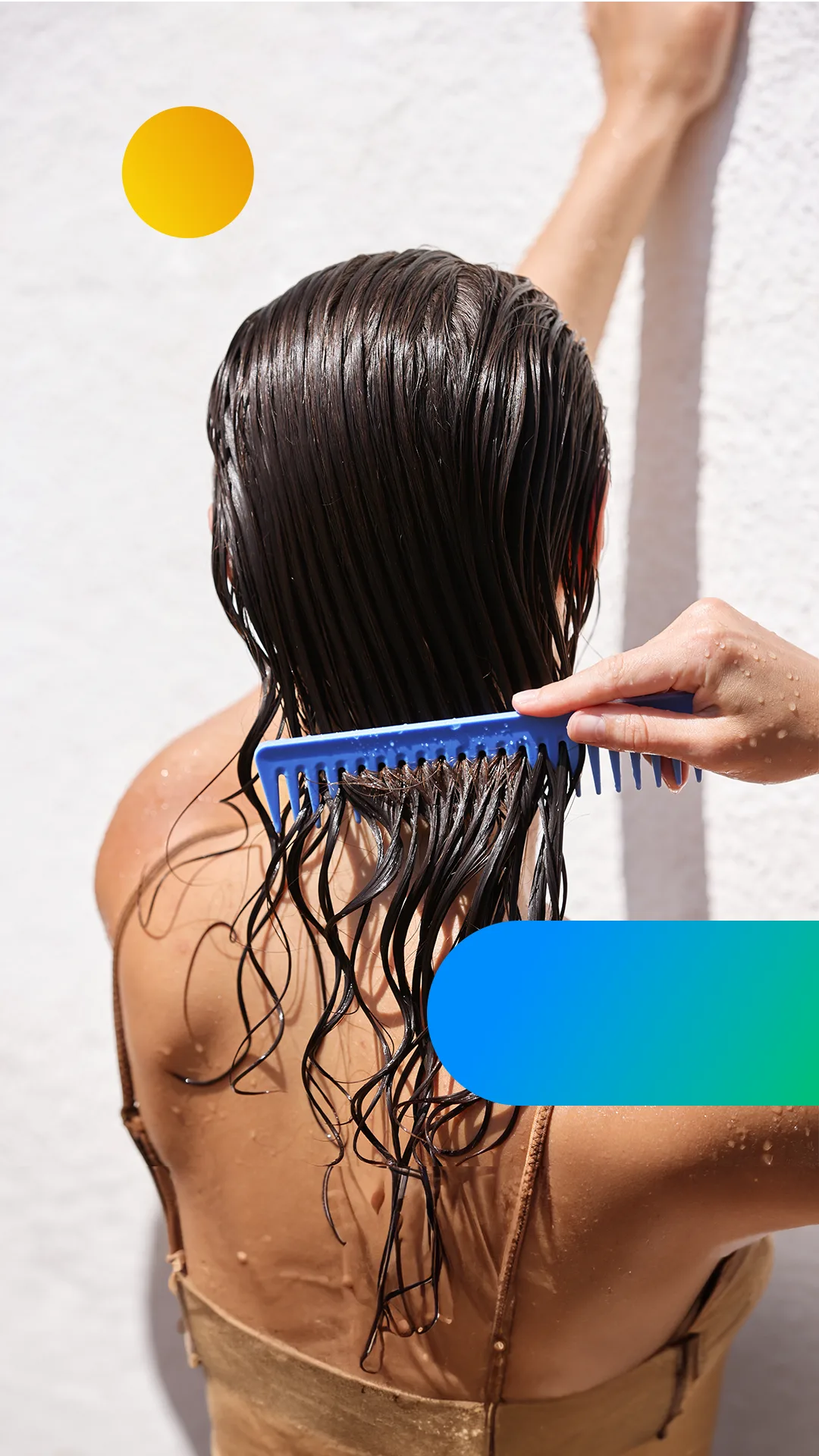 A woman with freshly washed hair stands under the shower, trying to comb it.