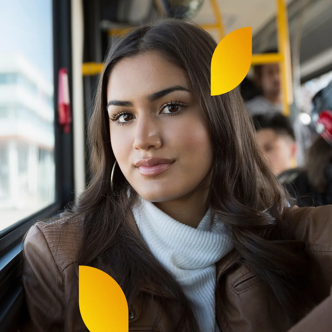 Portrait of a woman with dark hair sitting in public transportation.