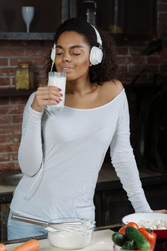 a woman listening to music while drinking milk