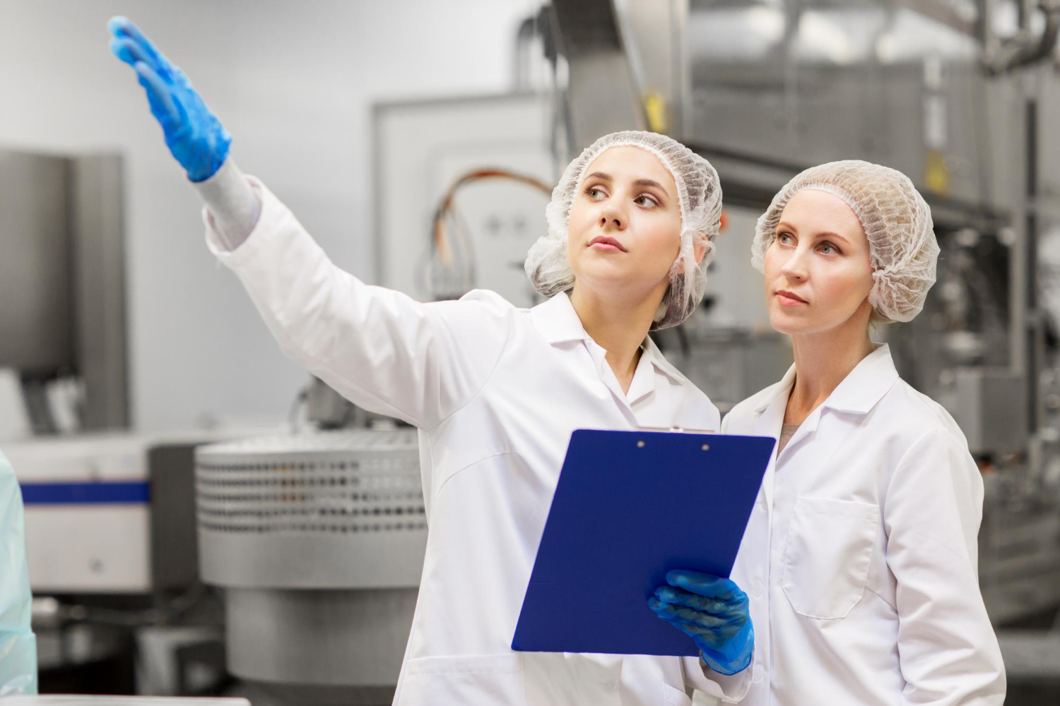 woman pointing left to a colleague in a factory