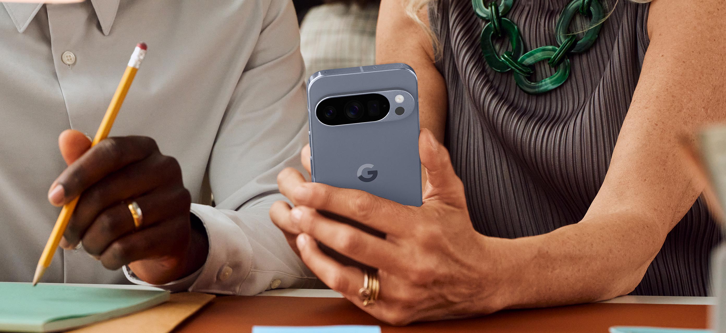 A close-up shot of a person’s hands holding a gray Google Pixel phone.