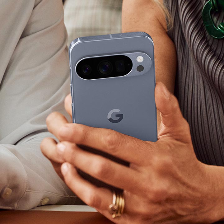 A close-up shot of a person’s hands holding a gray Google Pixel phone.
