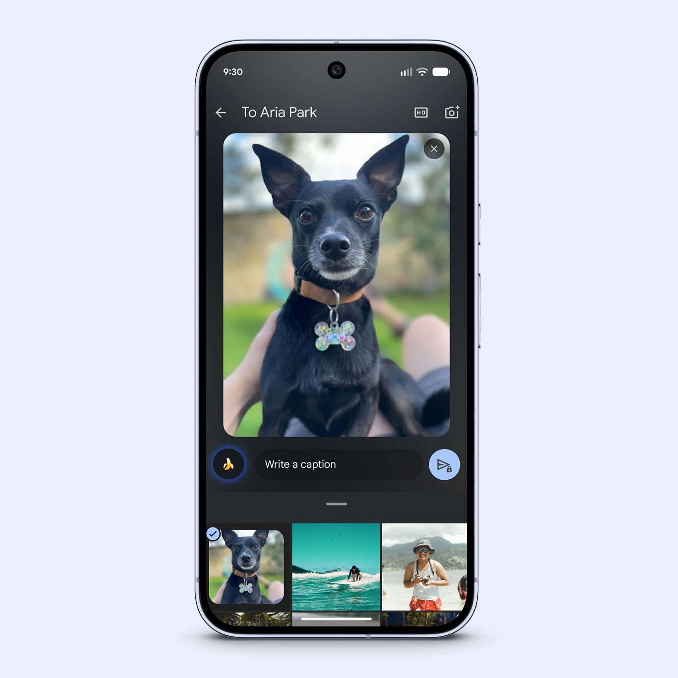 A screenshot of a photo-sharing interface on a smartphone. The main image shows a small black dog sitting outdoors wearing a colorful bone-shaped tag. Below the photo is a text field prompting to "Write a caption" next to a small banana emoji icon. A carousel of other photos is visible at the very bottom.