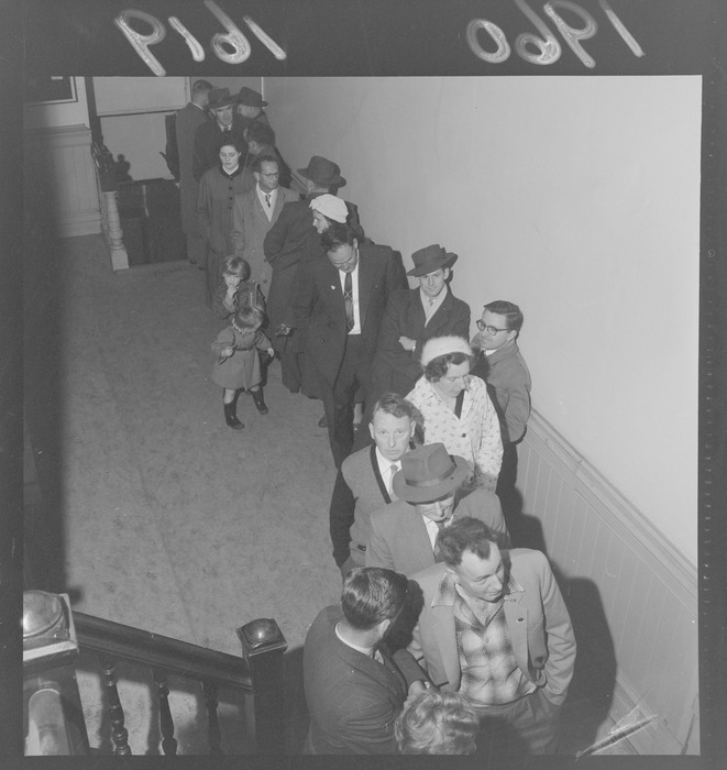 Mid century photo of large crowd queuing in a hallway