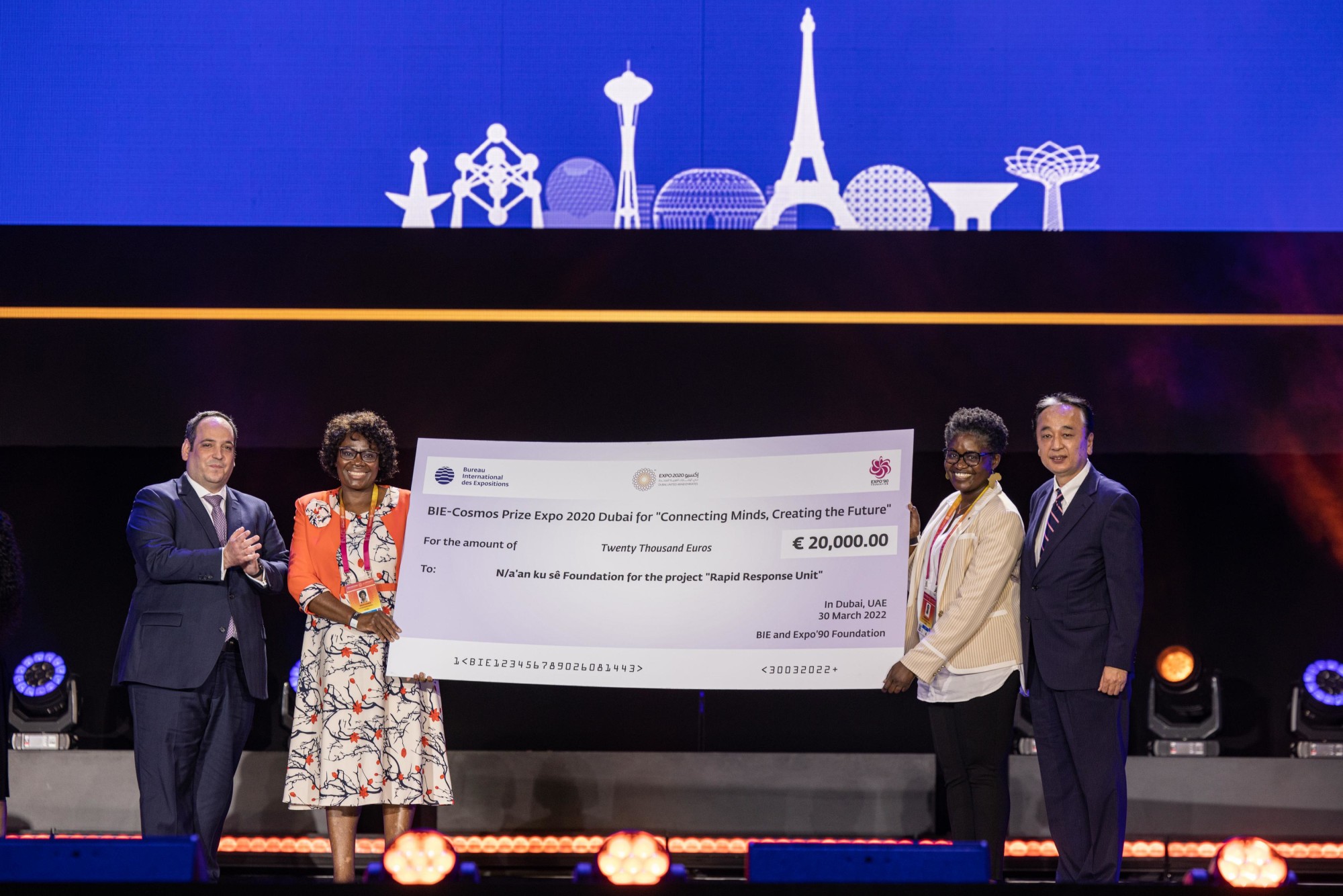 His Excellency Dimitri Kerkentzes (L1), Secretary General of the Bureau International des Expositions awards Nangula Uaandja (L2), Commissioner General of the Namibia Pavilion the BIE-Cosmos Prize for “Connecting Minds, Creating the Future