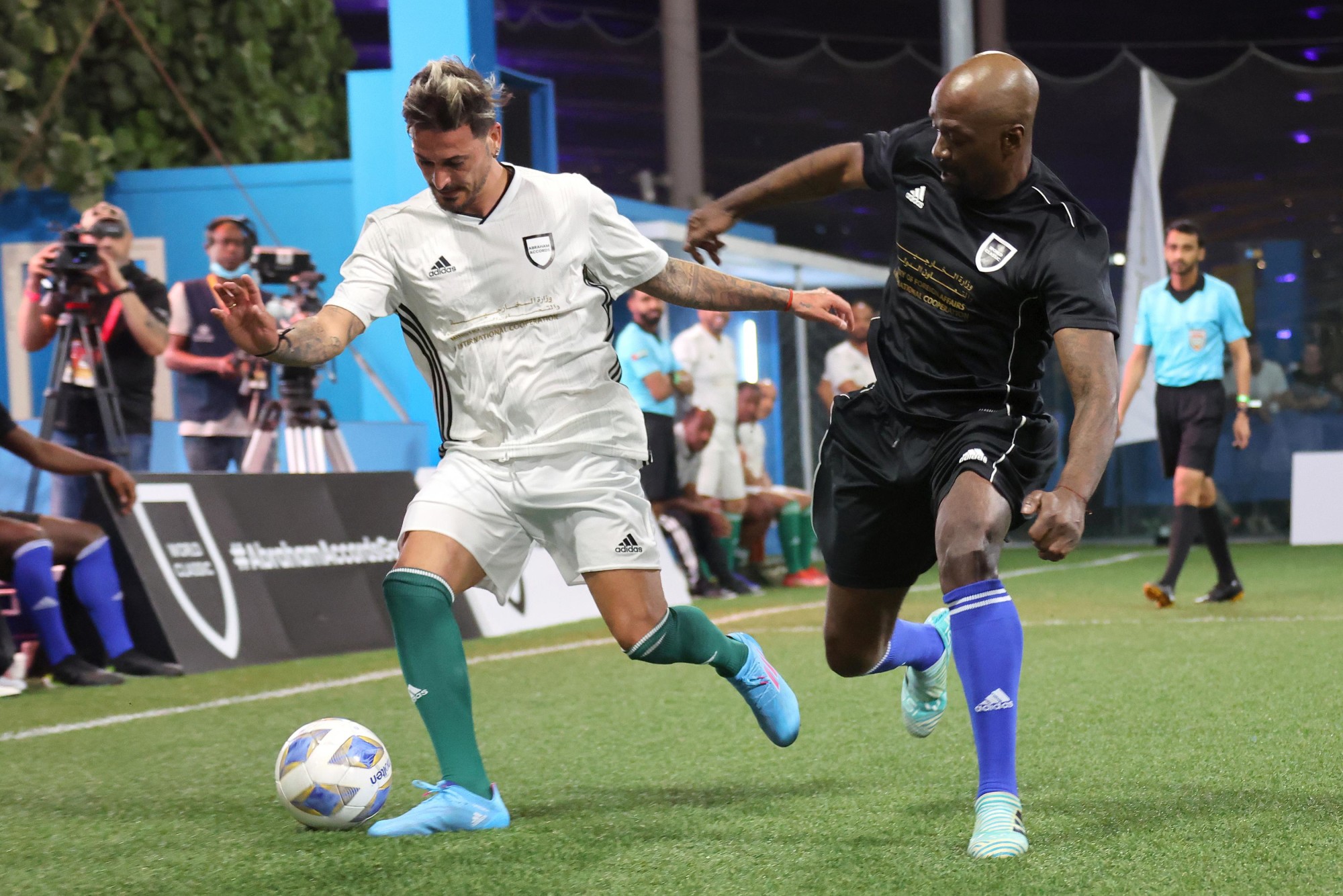 Former Israeli footballer and Abraham Accords team member Maor Buzaglo (L) in action against former French footballer and World Classic team member Claude Makélélé during an exhibition match for the Abraham Accords Games at the Sports, Fi