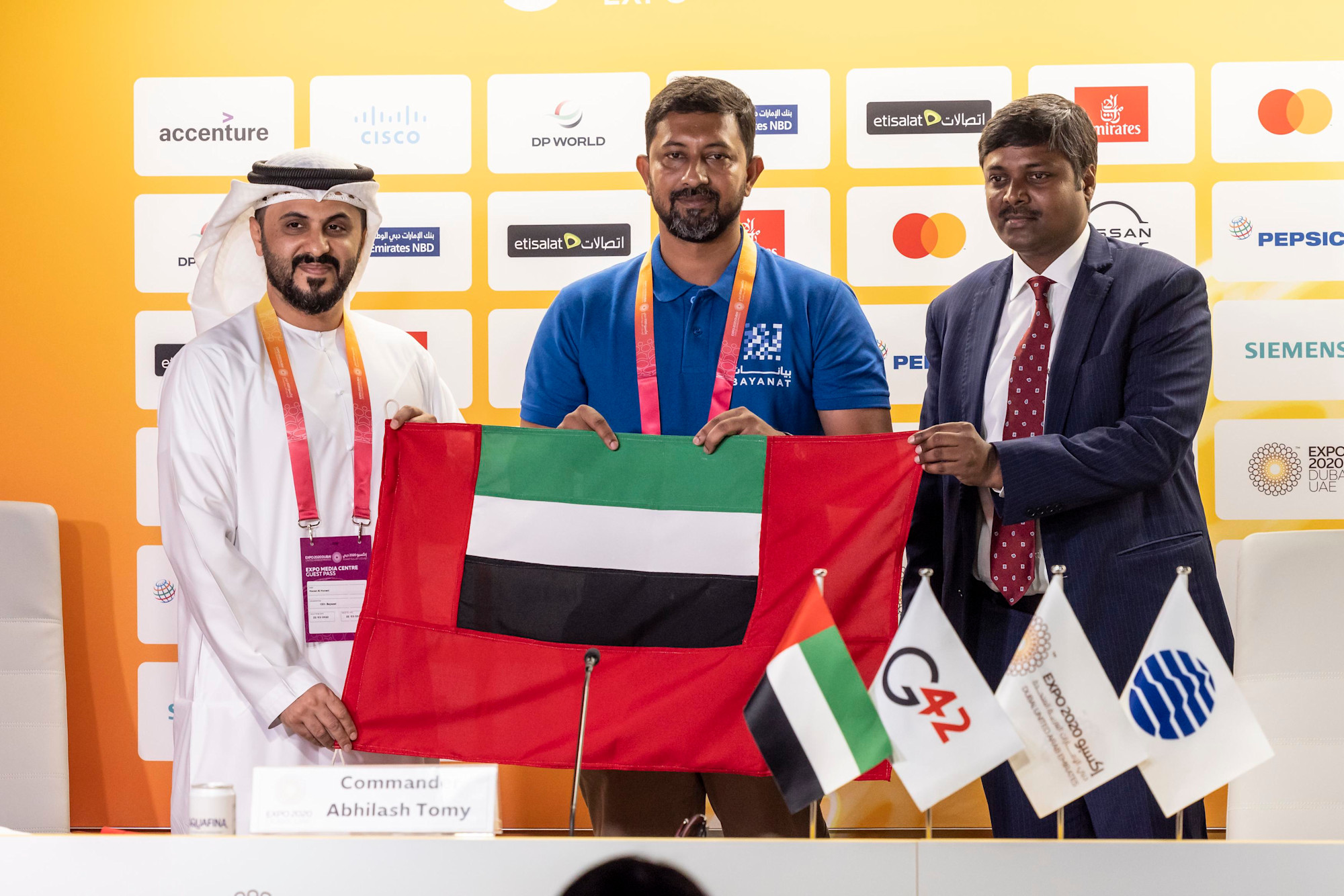 Hasan Al Hosani (L), CEO of Bayanat and Sandeep Kumar Bayyapu (R), Deputy Chief of Missions at the Embassy of India in the UA present the UAE Civil Ensign to Commander Abhilash Tomy (C), retired Indian Naval Officer, Yachtsman and first Indi