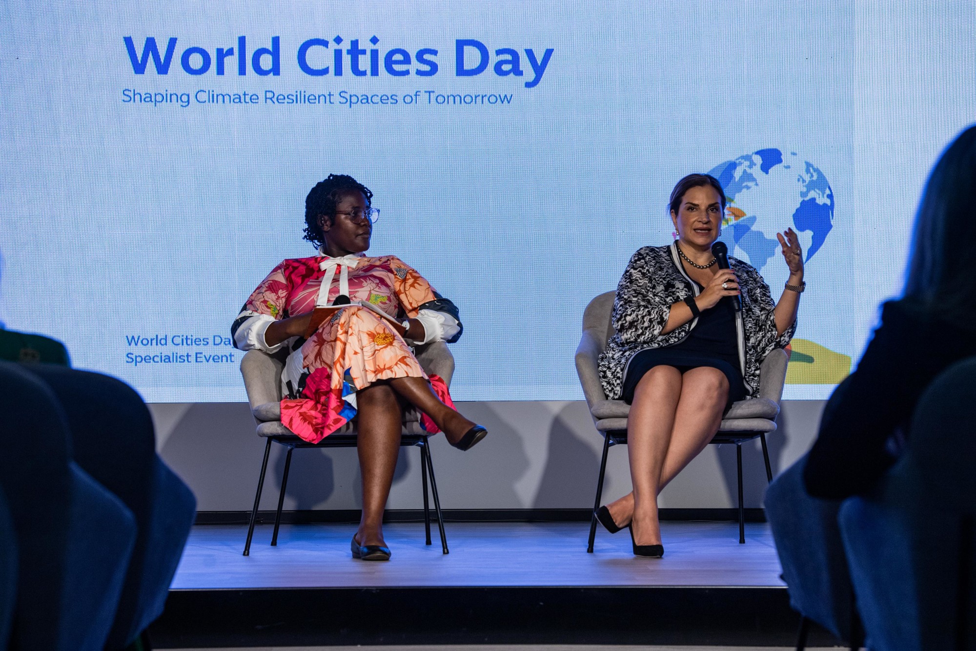 Joy Chadika (L) and Nadimeh Mehra, Vice President, District 2020 Transition Unit (R) speaks at the World Cities Day event m7594
