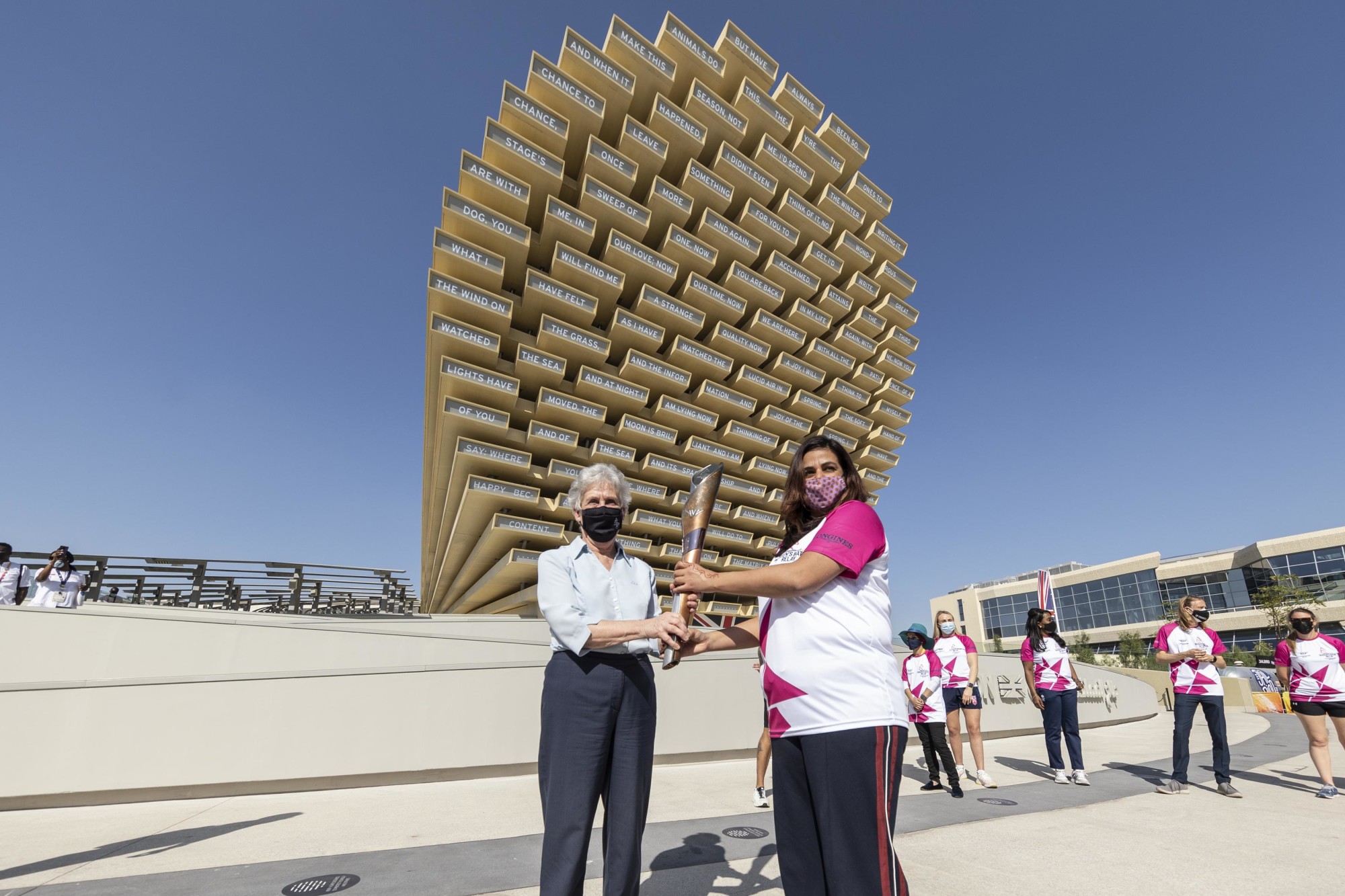 Dame Louise Martin (L), President of the Commonwealth Games Federation hands over the baton to Navkiran Mann (R), Baton Bearer as part of the Queen-s Baton Relay event during the United Kingdom National Day celebrations m46088