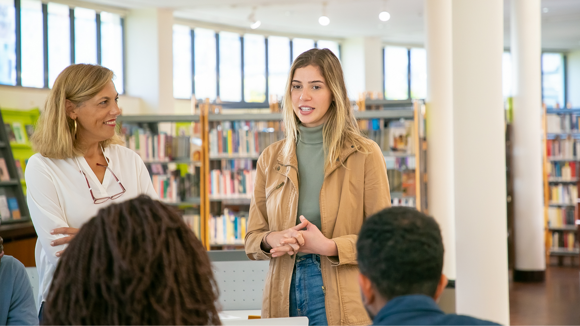 Mentor teacher supporting a student teacher in a school library.