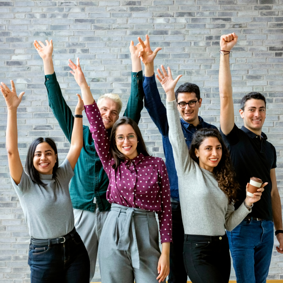 Mentors and mentees celebrate National Mentoring Month with arms raised in the air and happy faces.