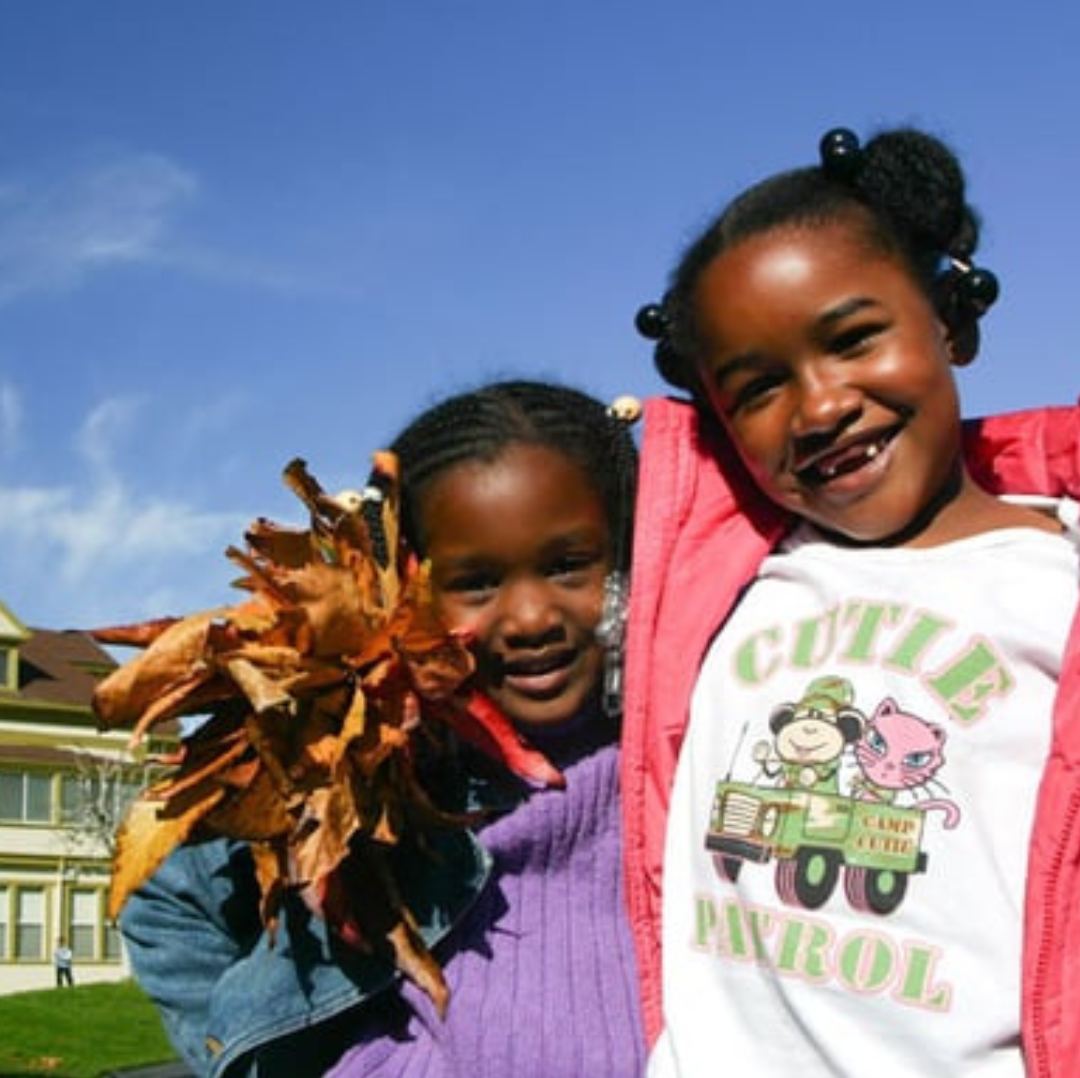 Two students at St. Vincent Day Home standing in front of the historical building.